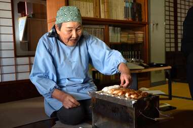 Grandmother Hitomi making lunch for her guests.